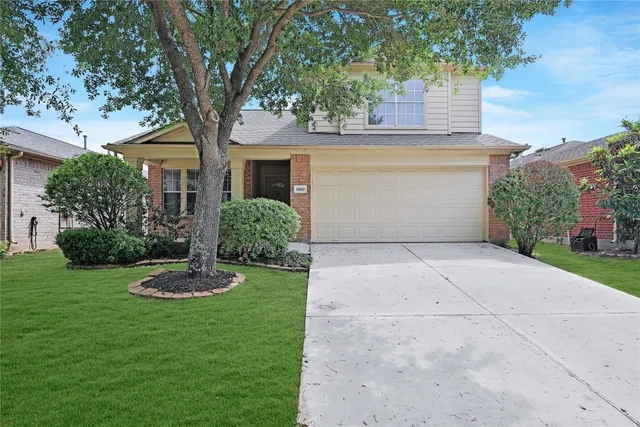 a front view of a house with a yard garage and plants