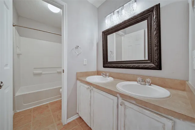 a bathroom with double sink and a mirror