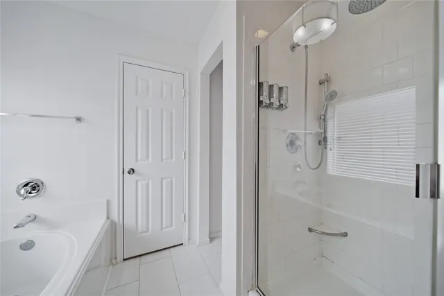 an empty room with wooden floor ceiling fan and window