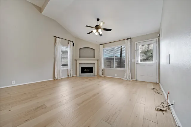 a view of empty room with wooden floor and fireplace