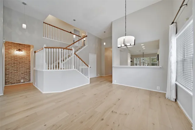 a view of a big room with wooden floor and a kitchen