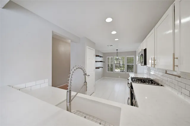 a kitchen with stainless steel appliances granite countertop a stove sink and cabinets