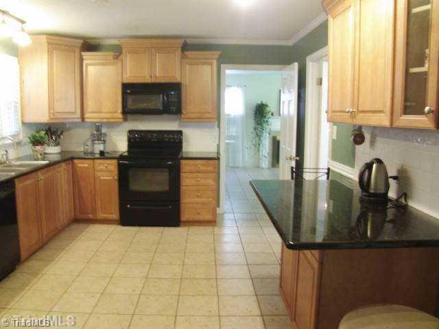 3205 Pine Needles Road High Point, NC 27265 - Photo 6 of 16 Kitchen. Kitchen has newer kitchen cabinets, granite counter tops, black appliances, tile floors, and note the neat island for eating or working...there is a pantry as well