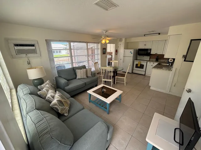 a living room with furniture a flat screen tv and a window