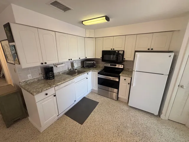 a kitchen with stainless steel appliances a refrigerator sink and cabinets