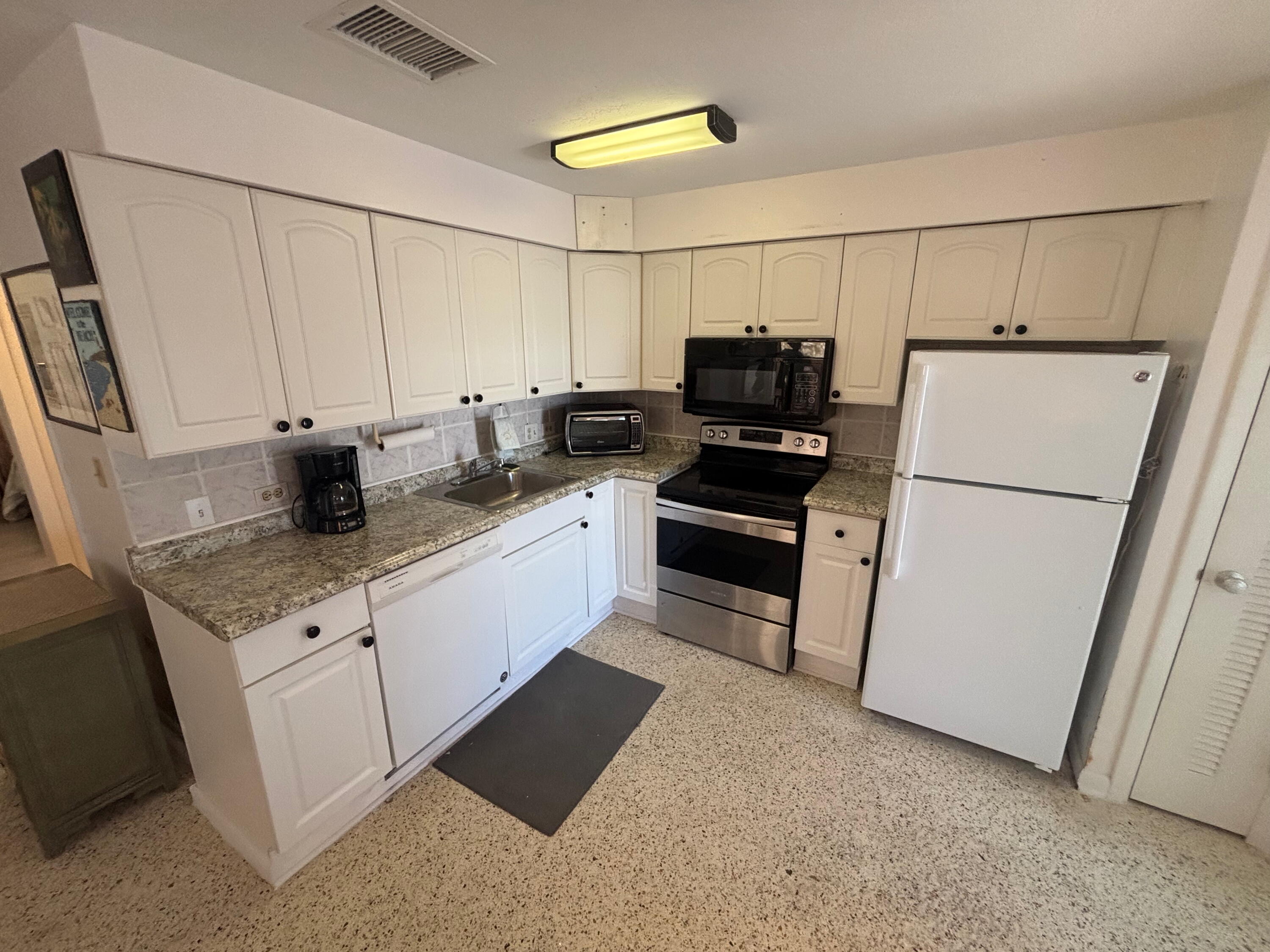 1433 Sunset Road Big Pine Key, FL 33043 - Photo 3 of 18 a kitchen with stainless steel appliances a refrigerator sink and cabinets