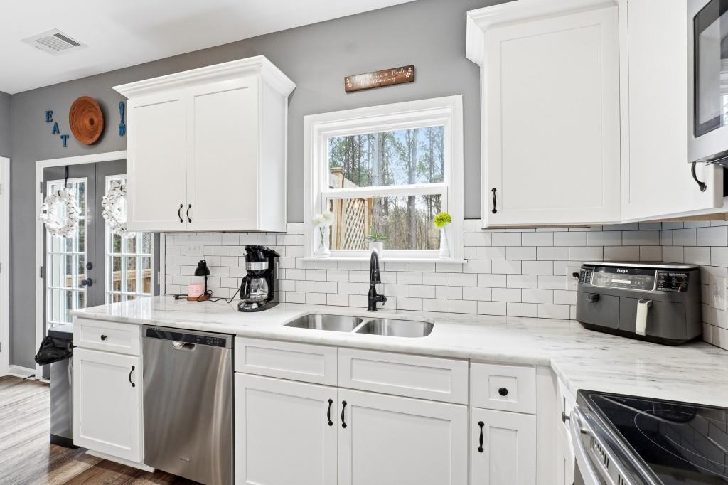 133 Pebblebrook Way Temple, GA 30179 - Photo 11 of 36 a kitchen with stainless steel appliances a sink a stove and white cabinets