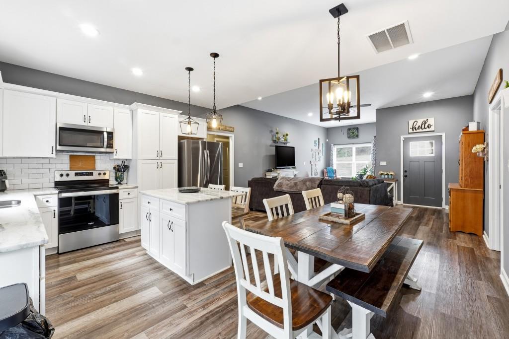 133 Pebblebrook Way Temple, GA 30179 - Photo 13 of 36 a kitchen with stainless steel appliances kitchen island granite countertop a kitchen island hardwood floor sink stove dining table and chairs