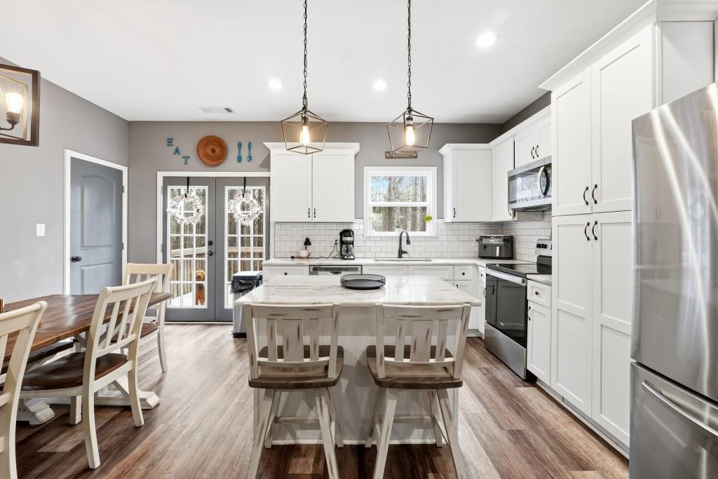 133 Pebblebrook Way Temple, GA 30179 - Photo 10 of 36 a kitchen with stainless steel appliances kitchen island granite countertop a refrigerator a stove and white cabinets with wooden floor