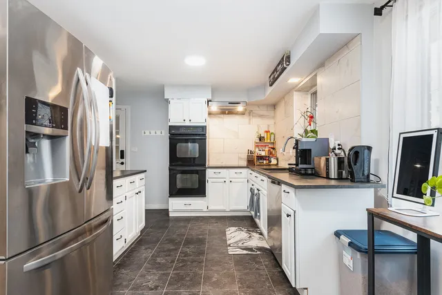 a kitchen with stainless steel appliances a refrigerator sink and microwave