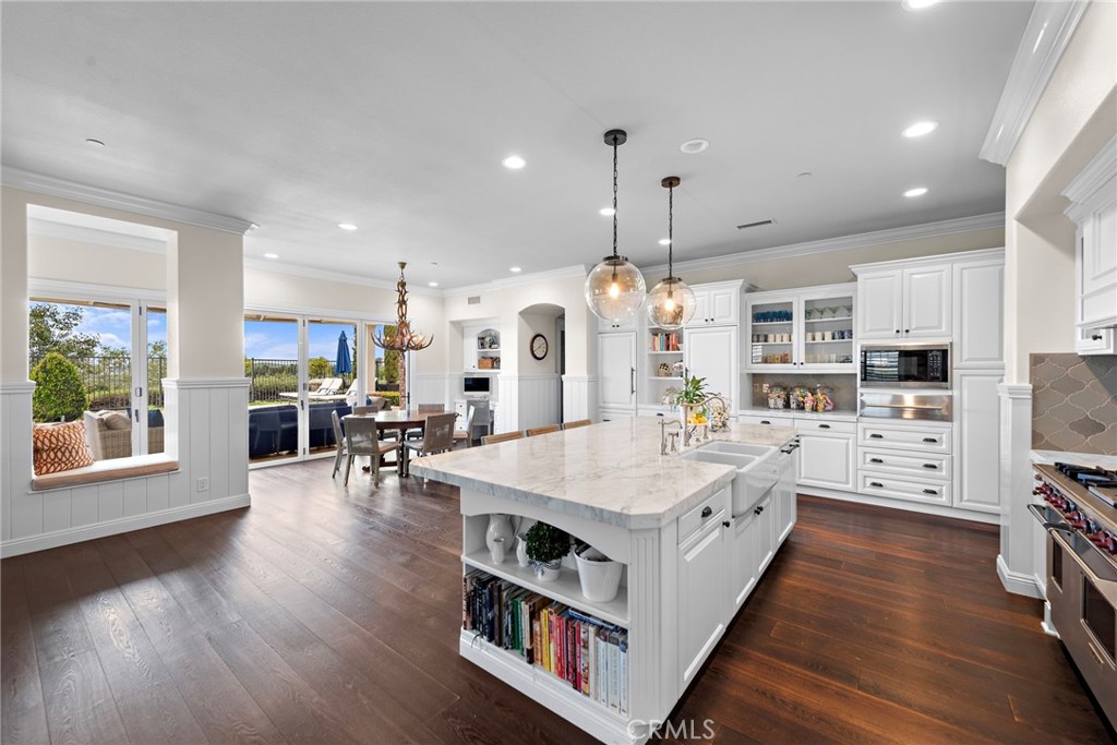 15 Starlight Ladera Ranch, CA 92694 - Photo 9 of 36 a large kitchen with kitchen island a large island a sink a stove and wooden floor