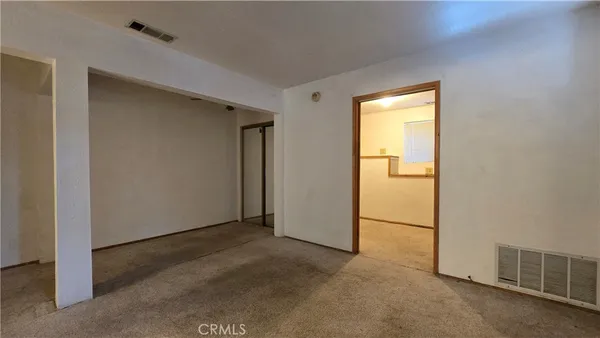 a view of a refrigerator in an empty room