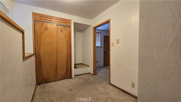 a view of a hallway with entryway and stairs