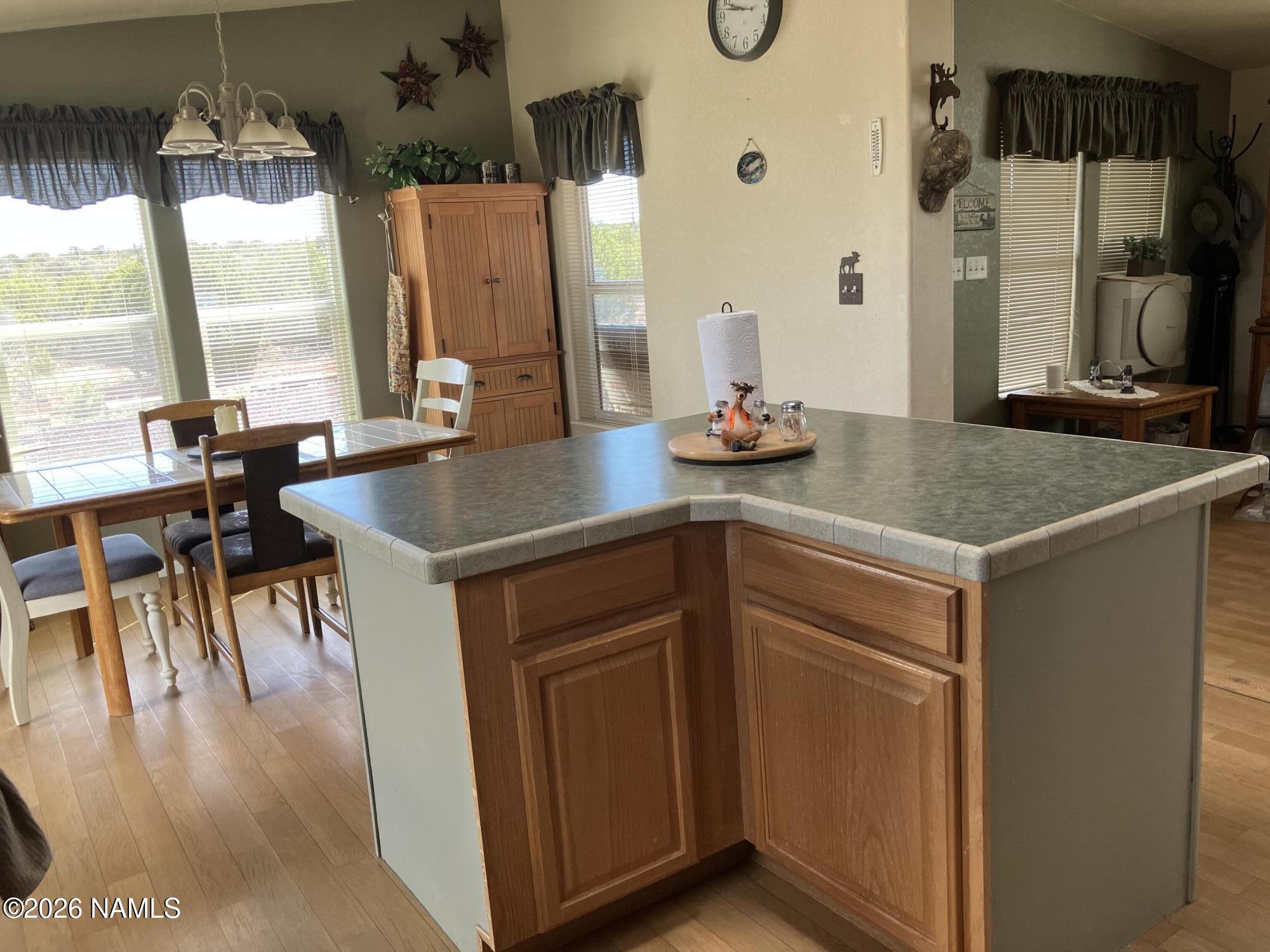 1431 East Cedar Road Williams, AZ 86046 - Photo 15 of 51 a kitchen with a wooden floor and a table with chairs