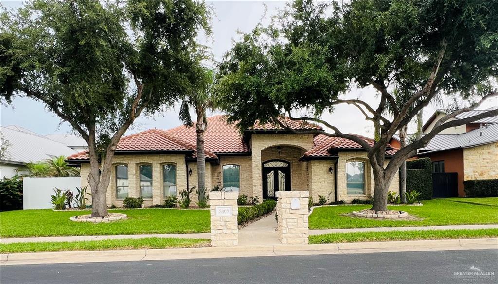 5809 North 3rd Street McAllen, TX 78504 - Photo 2 of 18 a front view of a house with a garden and trees