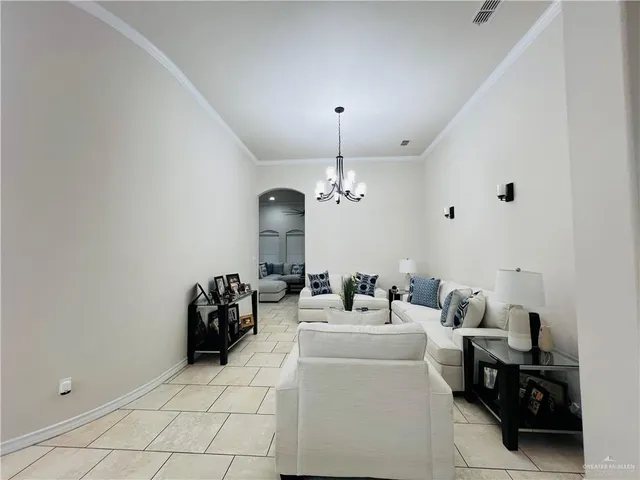 a living room with furniture a chandelier and a window