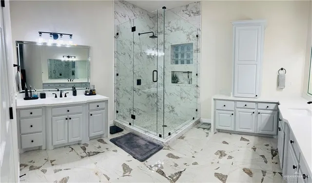 a spacious bathroom with double vanity sink a mirror and a shower