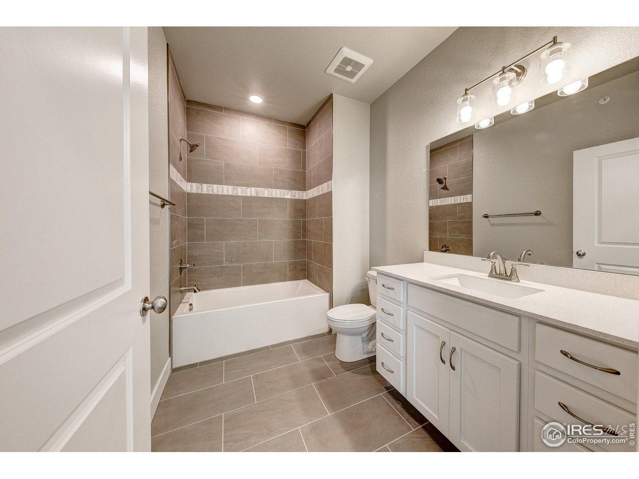 265 High Point Drive, Unit 201 Longmont, CO 80504 - Photo 17 of 26 a bathroom with a double vanity sink a toilet and a bathtub