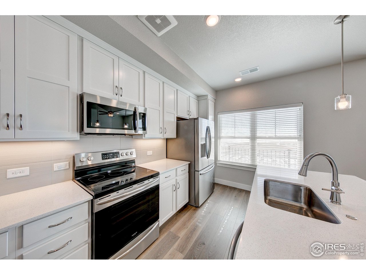 265 High Point Drive, Unit 201 Longmont, CO 80504 - Photo 2 of 26 a kitchen with a sink appliances cabinets and a window