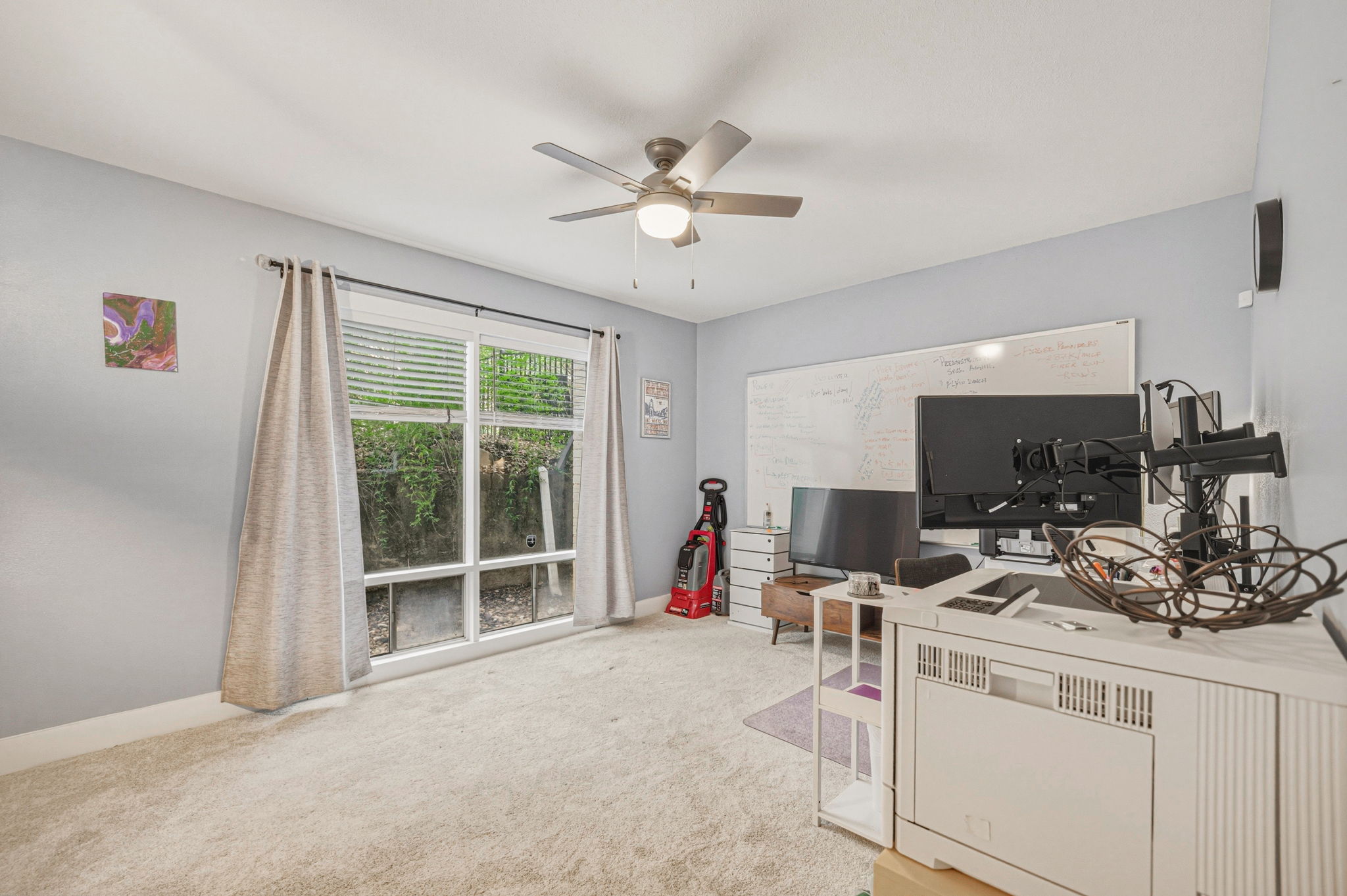 5332 Balcones Drive, Unit B Austin, TX 78731 - Photo 12 of 15 This room features a ceiling fan with integrated lighting, a large window with blinds and curtains, and light-colored carpeting