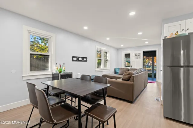 a living room with furniture a refrigerator and a dining table