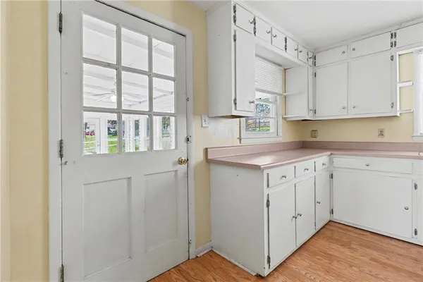a view of white cabinets and wooden floor