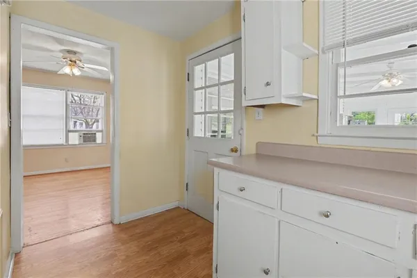 a kitchen with white cabinets and window