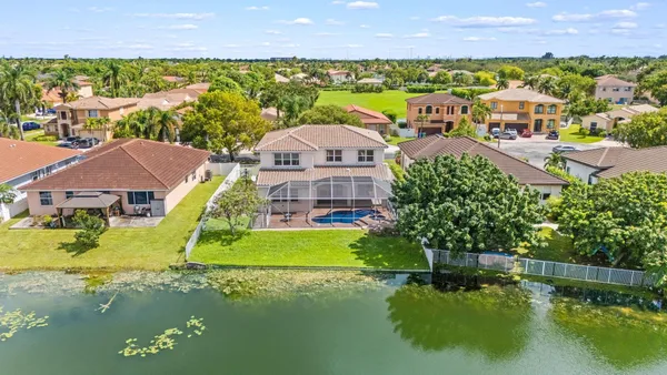 an aerial view of residential houses with outdoor space and a lake view
