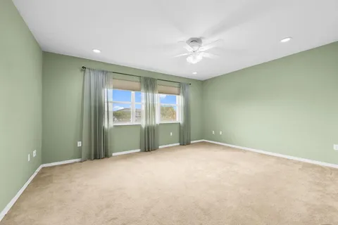 an empty room with a ceiling fan and window