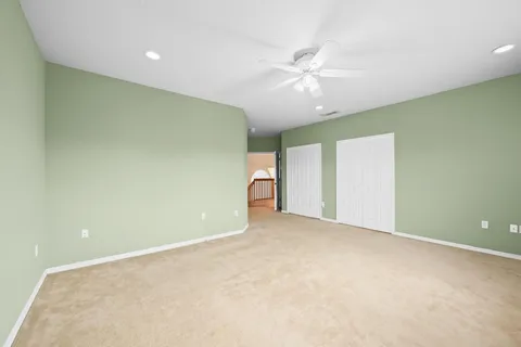 an empty room with a window and a ceiling fan