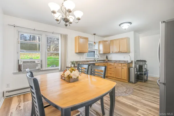 a kitchen with stainless steel appliances granite countertop a dining table chairs and chandelier