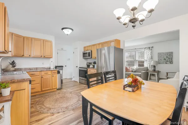 a view of kitchen with sink refrigerator dining table and chairs