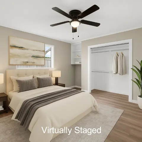 a view of empty room with wooden floor and ceiling fan