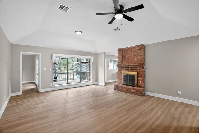 wooden floor fireplace and windows in an empty room