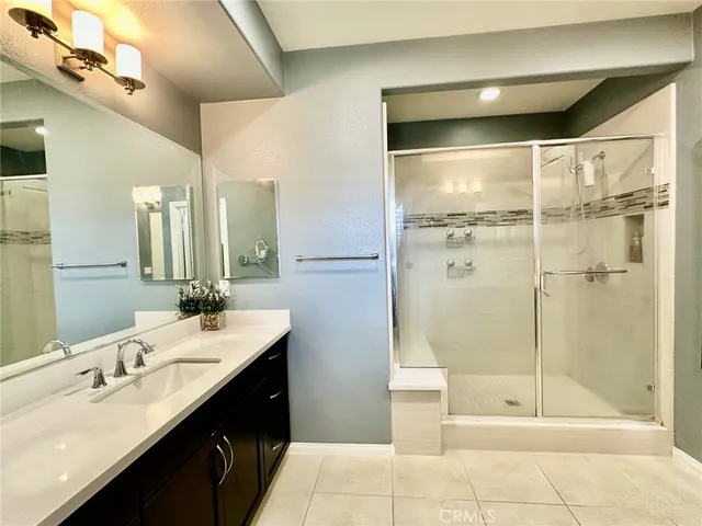a bathroom with a double vanity sink mirror and shower