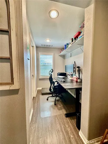 a view of a workspace with furniture and a window
