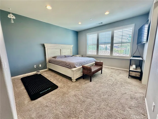 a bedroom with bed and a large window