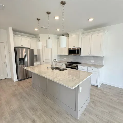 a kitchen with stainless steel appliances kitchen island a refrigerator sink and microwave