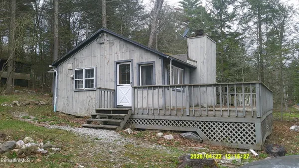 a view of a house with a small yard and wooden fence