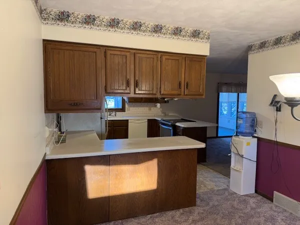 a kitchen with kitchen island granite countertop a sink stove and refrigerator