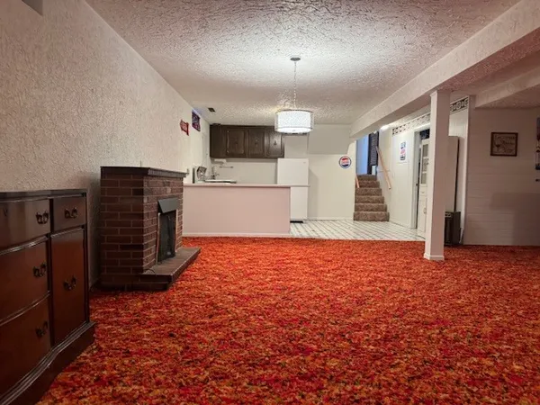a view of an empty room with a fireplace and a window