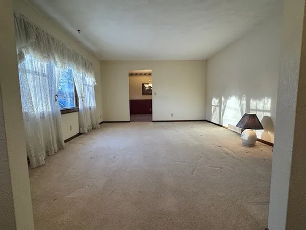 a view of an empty room with closet and windows