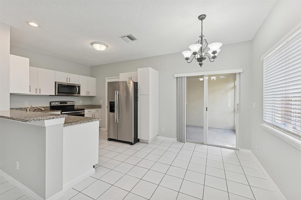 6007 Red Plum Court, Unit 465 Tamarac, FL 33321 - Photo 9 of 23 a view of a kitchen with stainless steel appliances granite countertop a refrigerator and a stove top oven