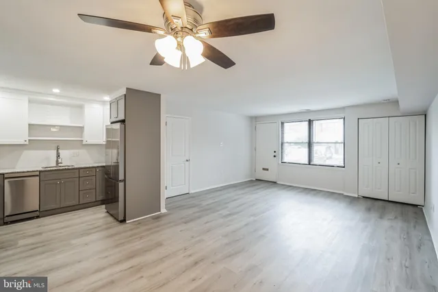 a view of a kitchen with a sink a ceiling fan and wooden floor