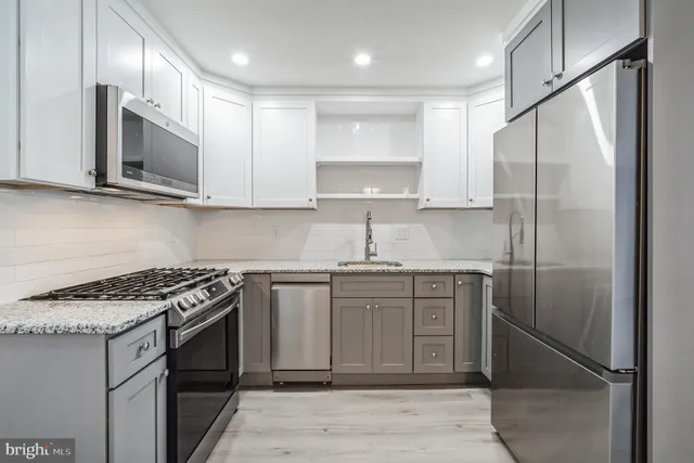 a kitchen with stainless steel appliances granite countertop a sink stove and refrigerator