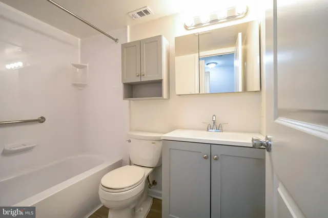 a bathroom with a granite countertop toilet a sink and a bathtub