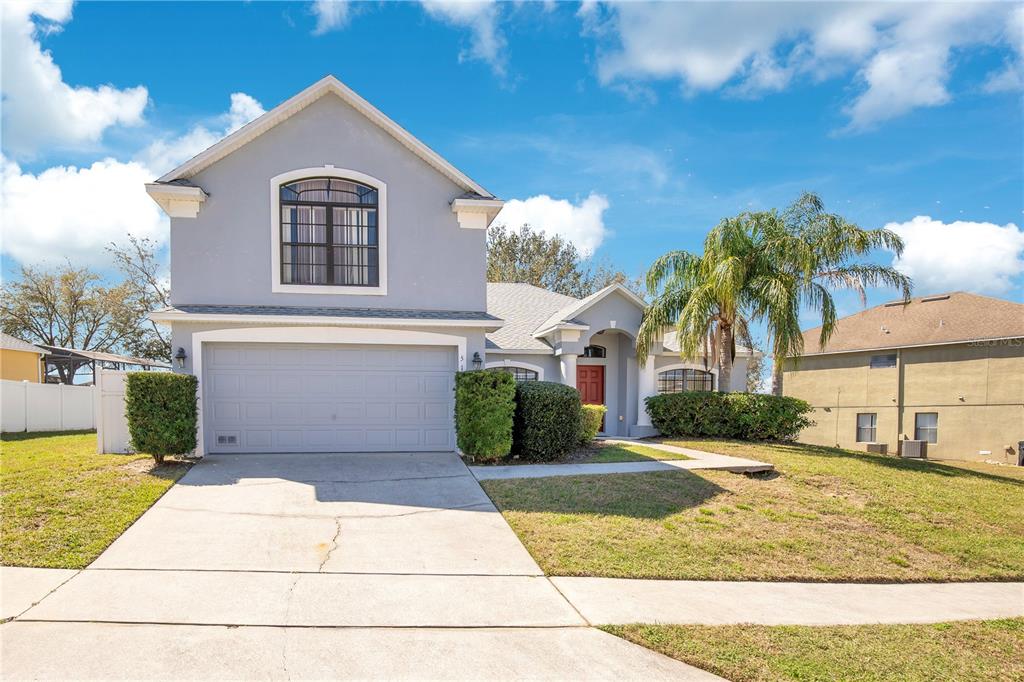 511 Coventry Road Davenport, FL 33897 - Photo 1 of 1 a front view of a house with a yard and potted plants