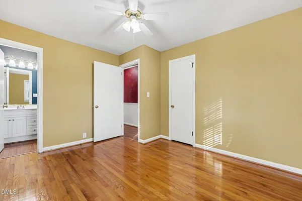 a view of a room with wooden floor and a chandelier fan