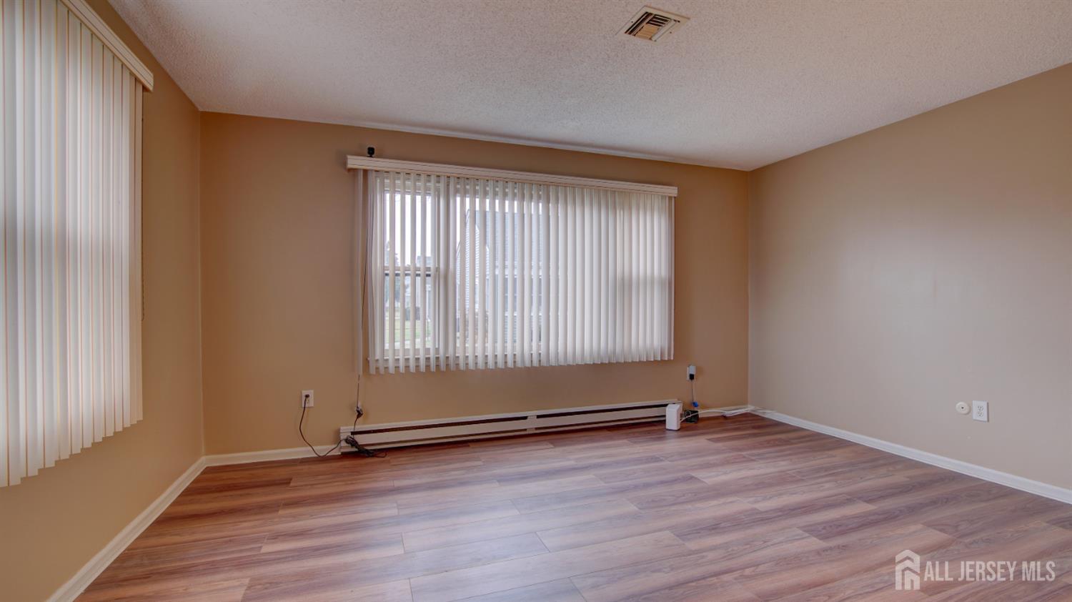 337A Old Nassau Road, Unit A Monroe Township, NJ 08831 - Photo 23 of 39 an empty room with wooden floor and windows