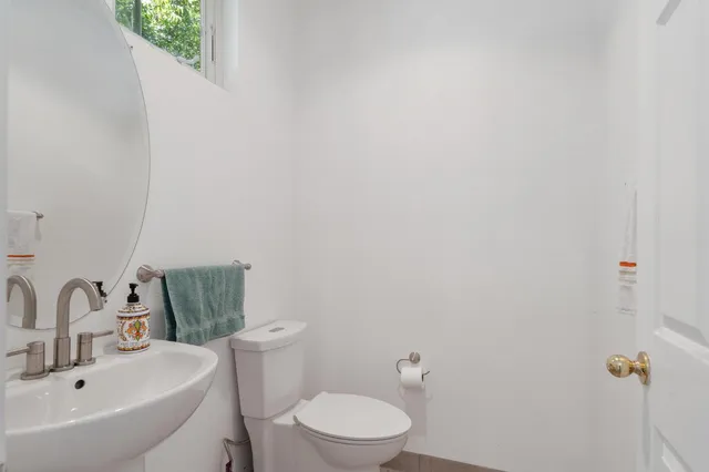 a bathroom with a sink mirror and toilet